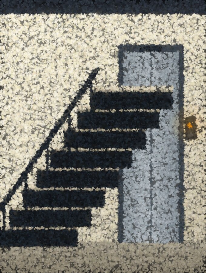 A flight of stairs rising beside a pair of lift doors in a plain lobby.