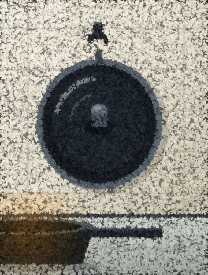 A heavy pan lid hanging on a hook on the tiled wall directly above a pan on the worktop.
