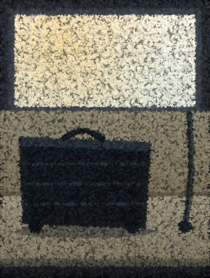A heavy case sitting unsecured on a car back seat with the belt hanging unused beside it.
