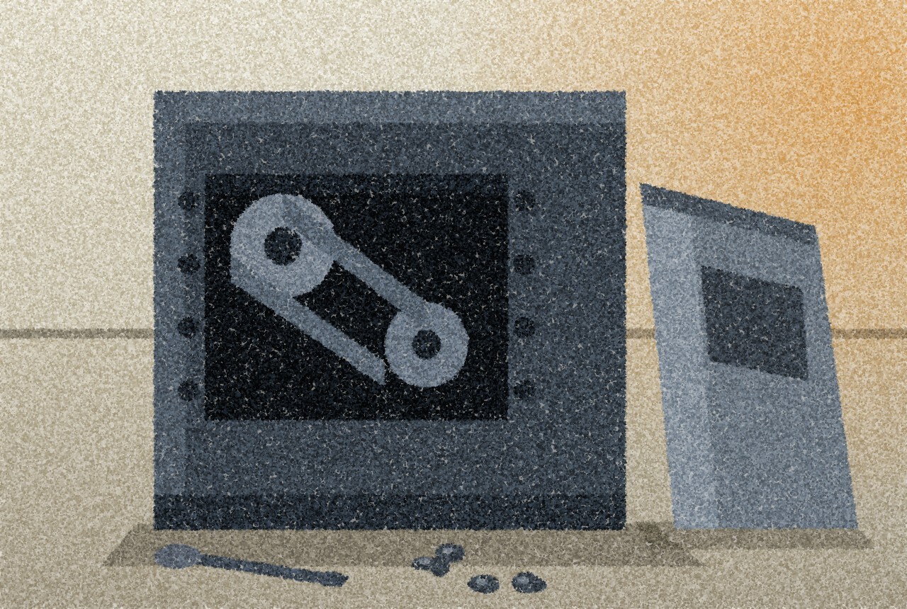 A machine with an access panel removed, a pulley and drive belt visible in the dark opening, the guard leaning against the machine and bolts and a spanner on the floor.