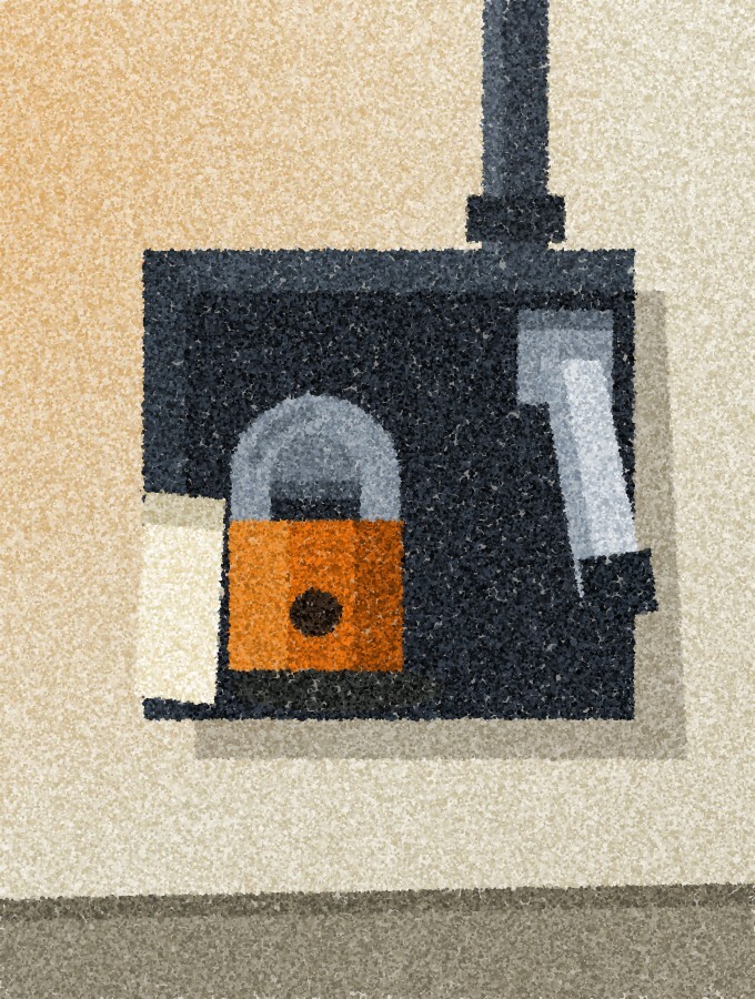 A wall-mounted isolator box with its lever thrown down and an orange padlock through the hasp, a blank tag hanging beside it.