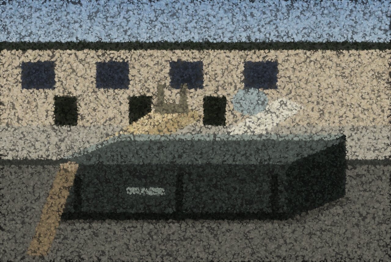 A steel skip on the road outside a terrace, filled with planks, board and a broken chair, a rolled carpet leaning against it.