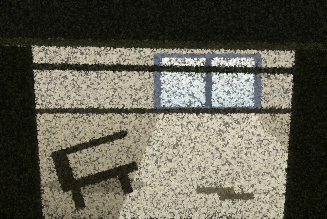 The view from under a desk: the dark underside overhead, a bright window and floor beyond, and a chair toppled on its side.