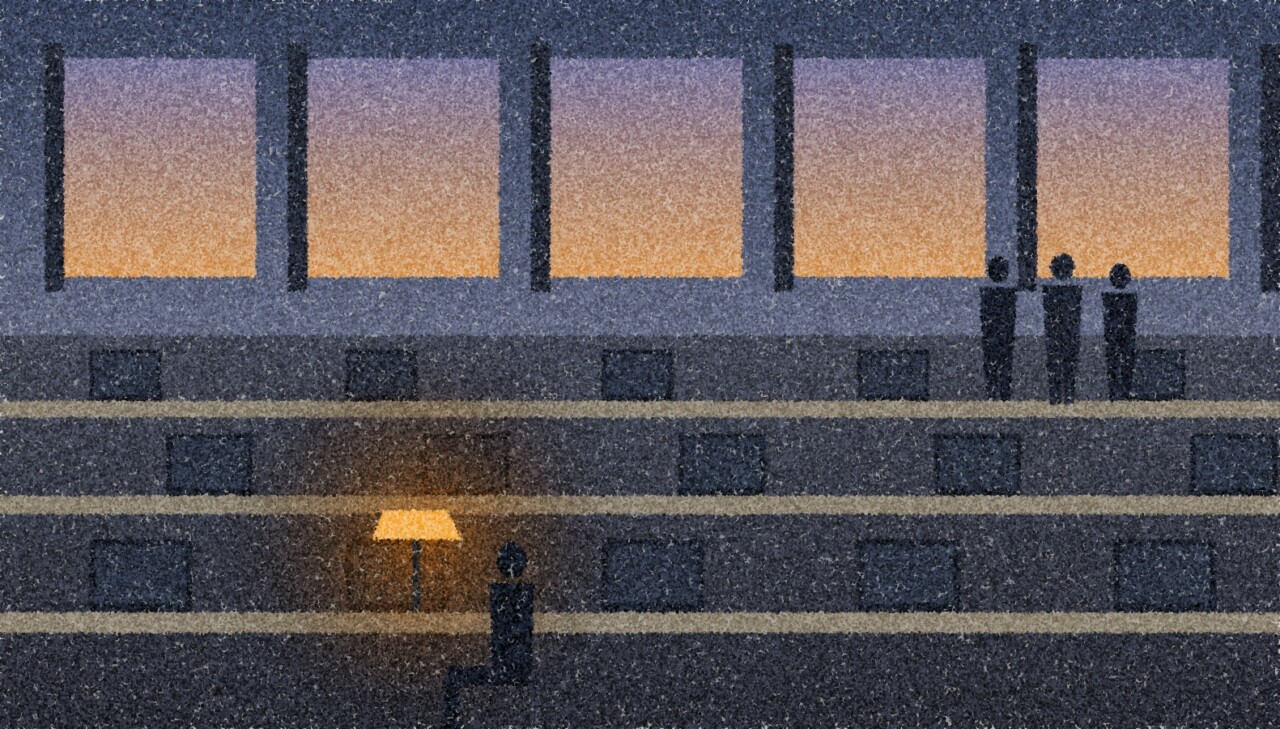 A pointillist illustration: an open-plan office at the end of the day, rows of empty desks and one occupied desk under a single amber lamp, a small group of colleagues standing together by the far windows.