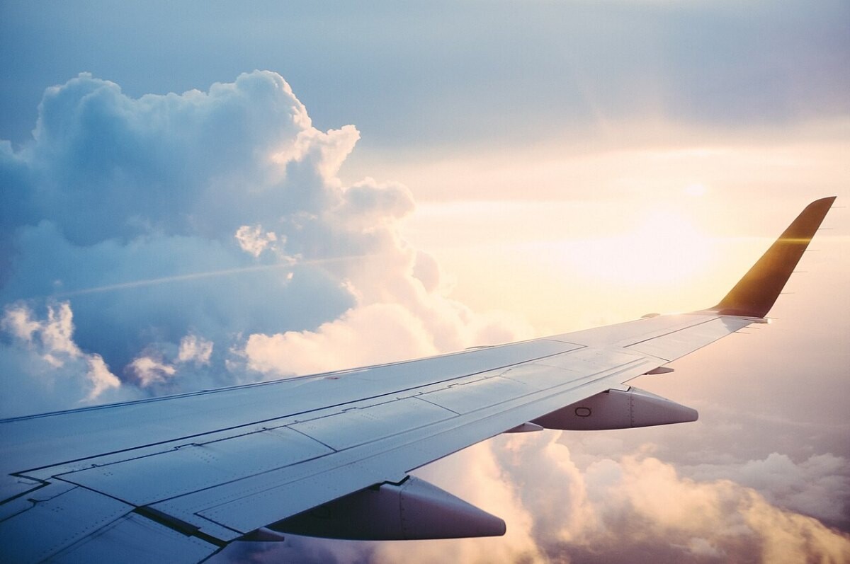 An airplane wing above the clouds