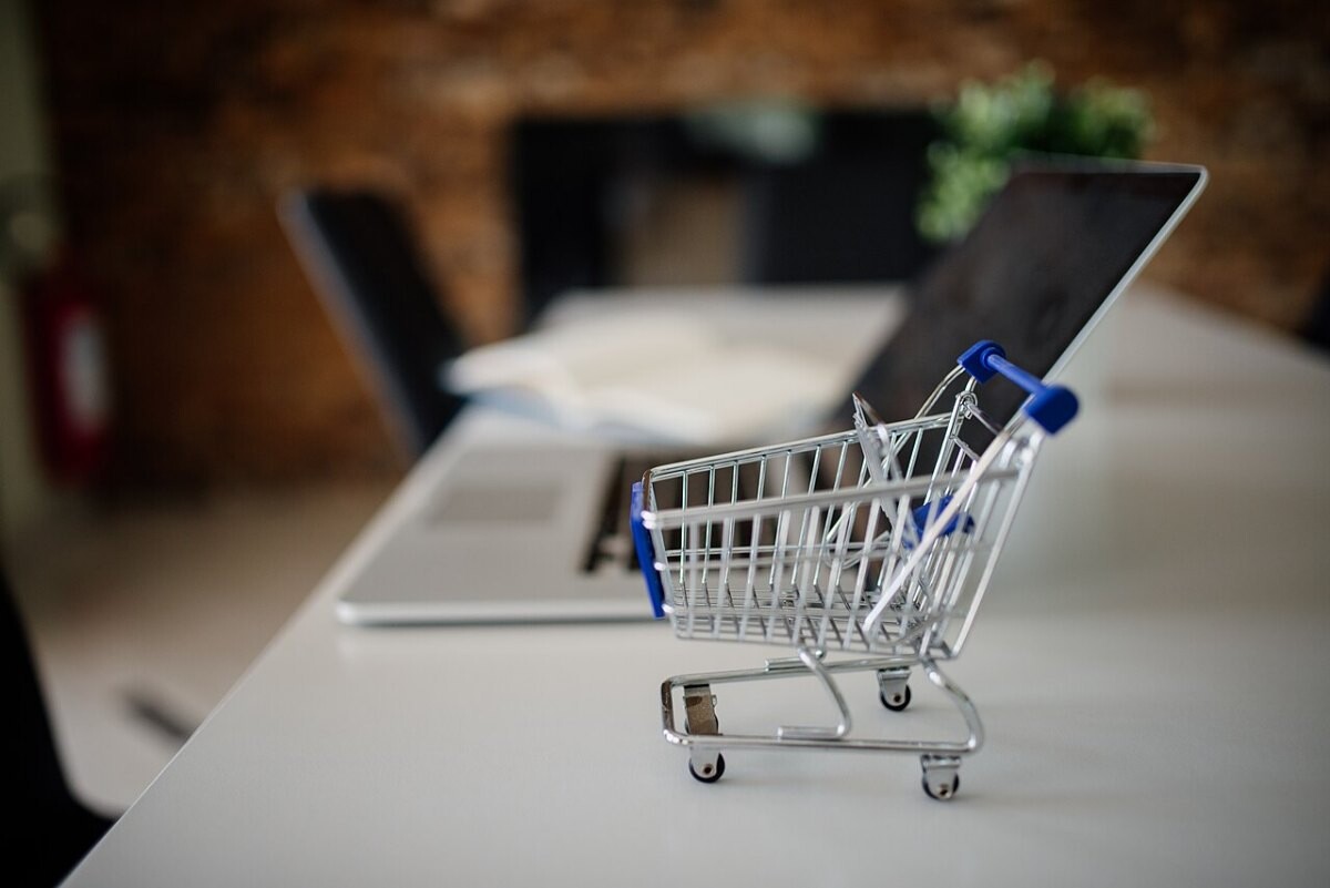 A toy shopping cart on a laptop