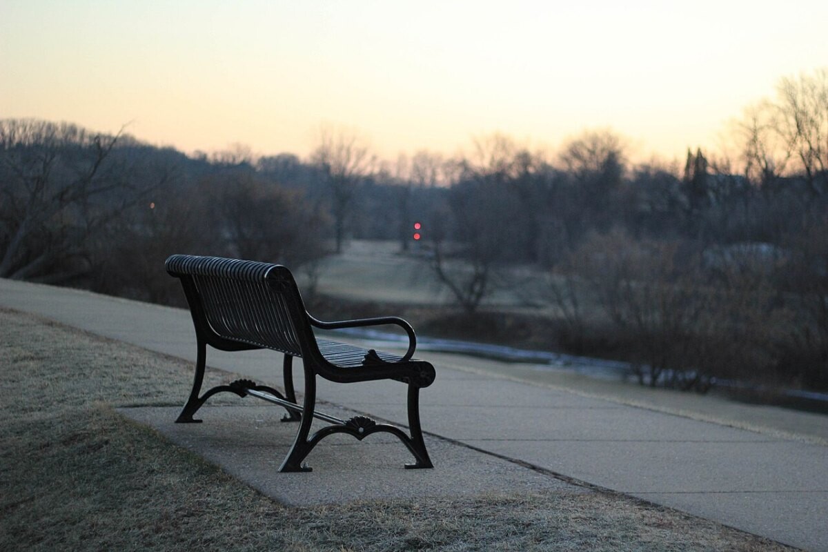 An empty park bench at dusk