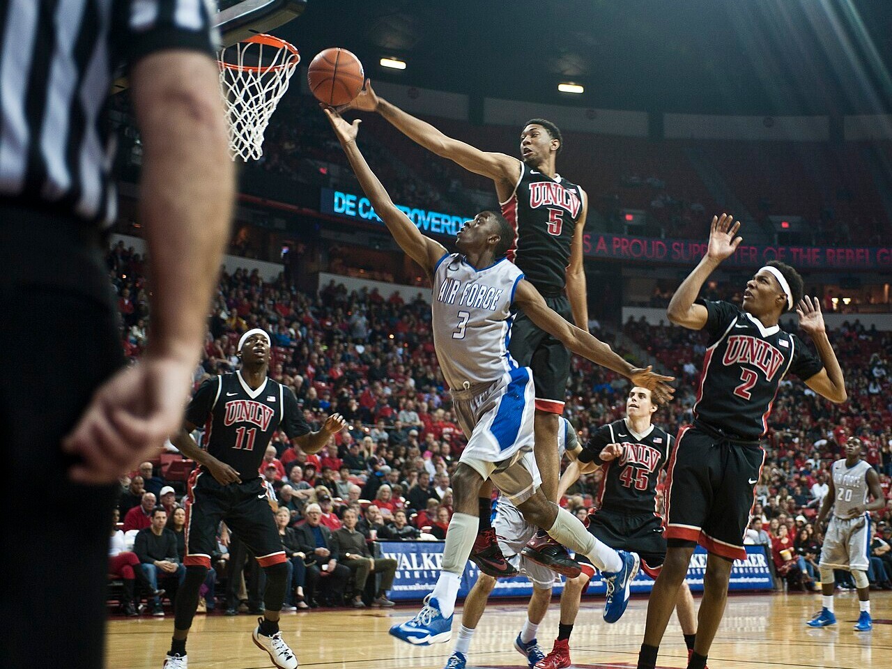 A college basketball player going up for a layup