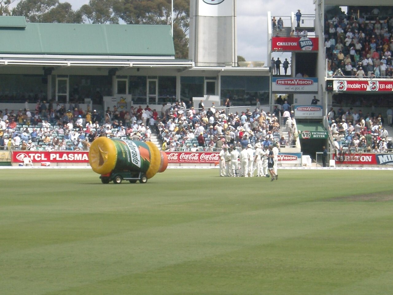 Cricketers gathered on the field during a drinks break in a Test match