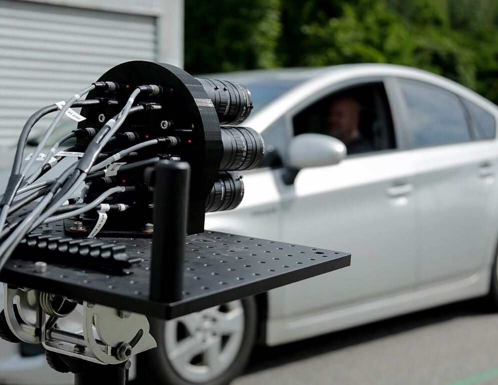 A multi-lens camera rig capturing faces in a passing car