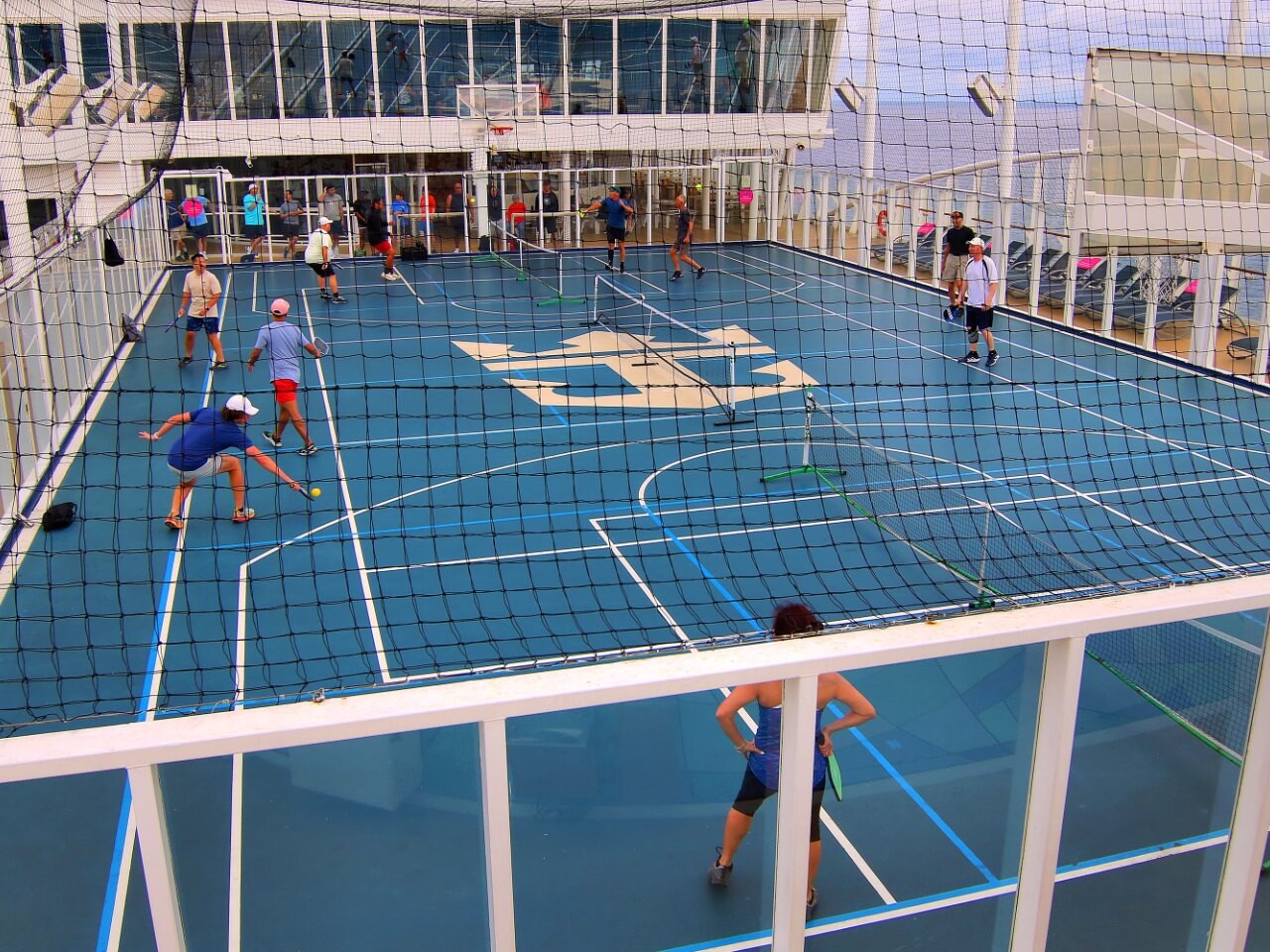Pickleball players in a doubles game on an outdoor sports court