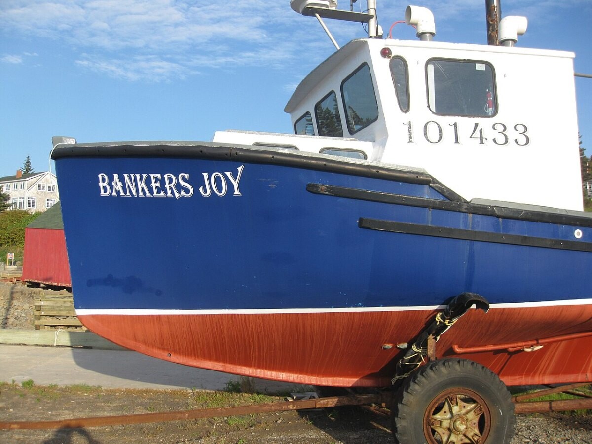 A freshly painted fishing boat sitting on the mud at low tide