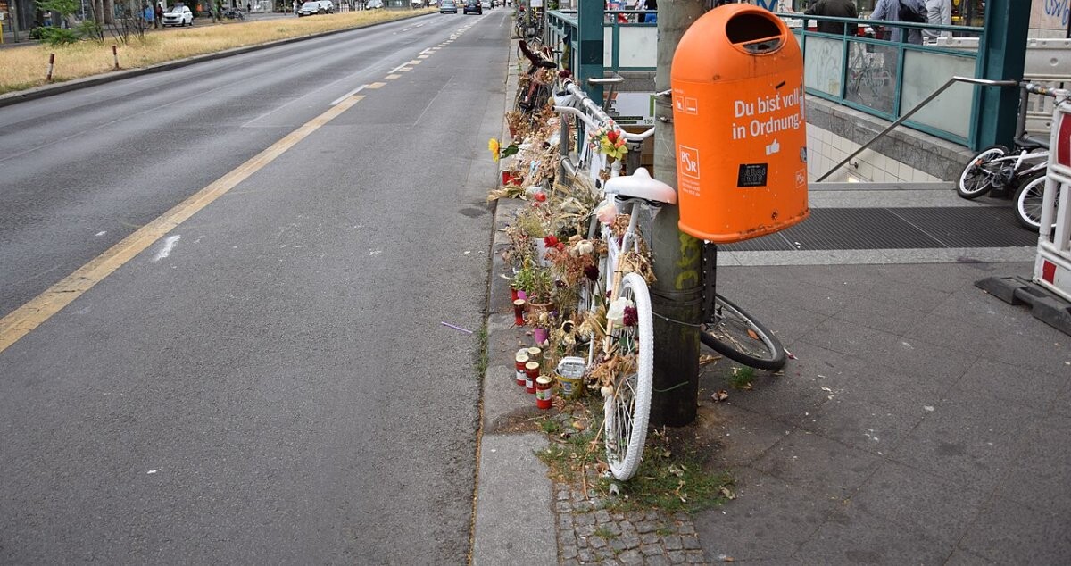 A white-painted ghost bike memorial on a Berlin street