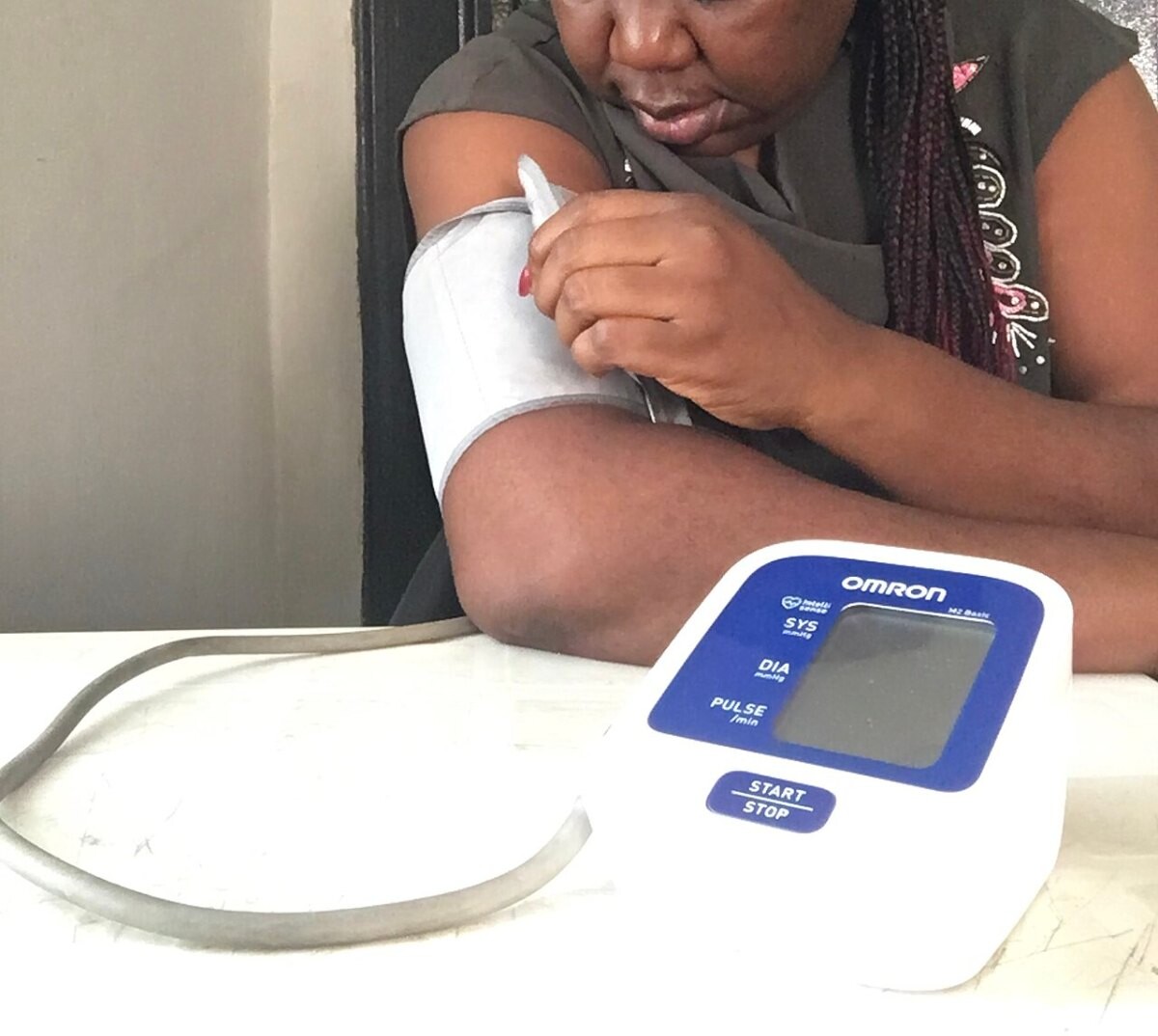 A person checking their blood pressure with a home monitor on the arm