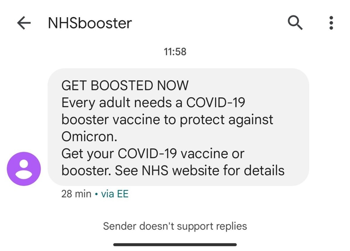 A phone screen showing an NHS text message urging people to get a booster vaccine