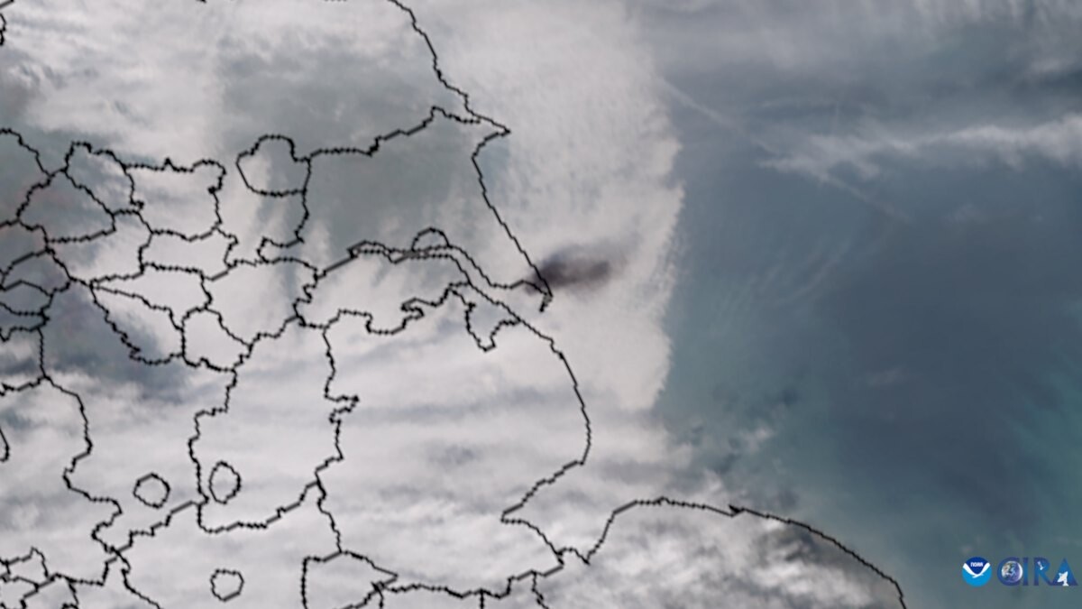 Satellite image of black smoke plumes over the North Sea off eastern England