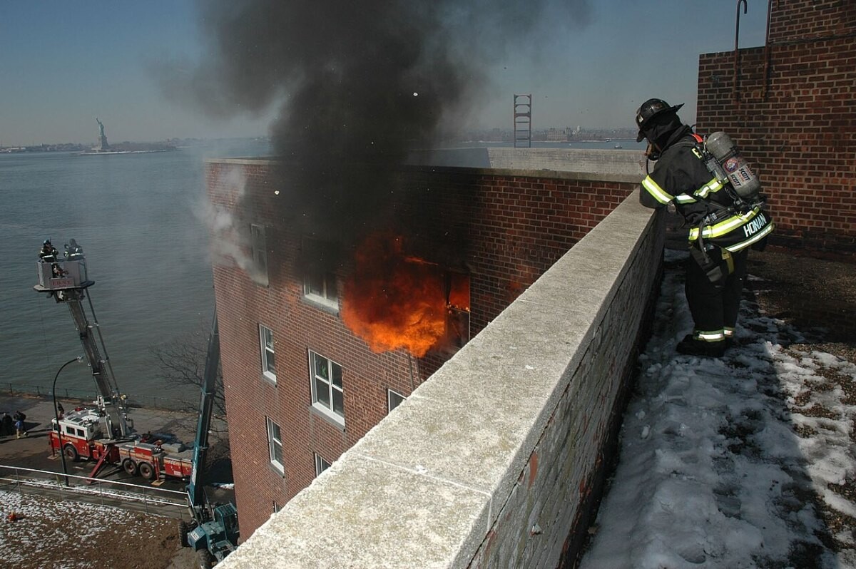 Flames and smoke pouring from an upper-floor window of an apartment block during a fire experiment