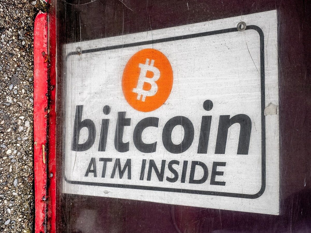 A sign reading bitcoin ATM inside in a shop window
