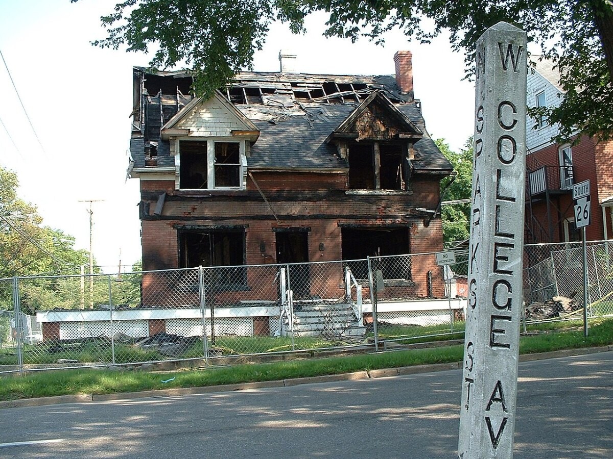 Exterior of a fire-damaged house with a collapsed roof