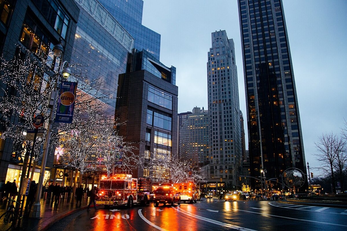 An ambulance and fire engine on a city street at dusk