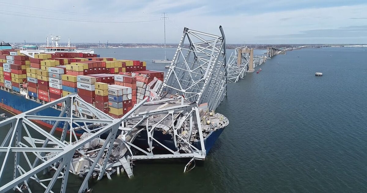 Aerial drone view of the collapsed Francis Scott Key Bridge lying across the bow of the container ship Dali